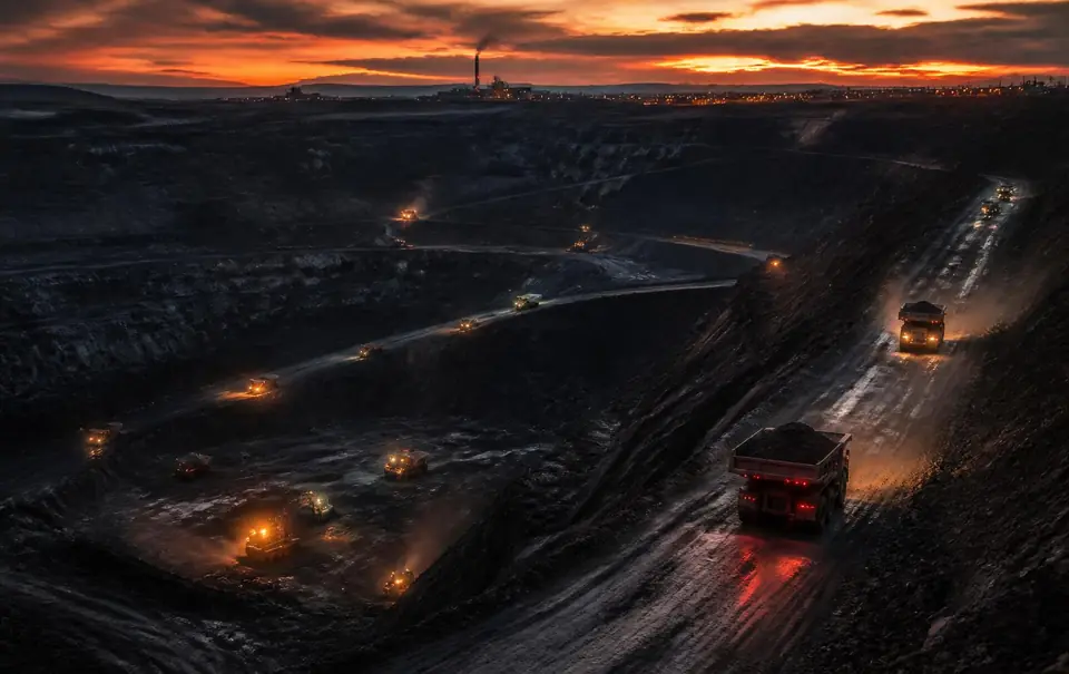 Tambang batu bara terbuka saat senja dengan armada haul truck